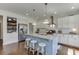 Well-lit kitchen with a blue island, granite countertops, stainless appliances, and sleek pendant lighting at 1788 Hanover West Ct, Lawrenceville, GA 30043