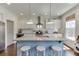 Modern kitchen features granite countertops, stainless appliances, a blue island, and ample natural light at 1788 Hanover West Ct, Lawrenceville, GA 30043