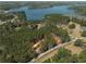 Aerial view showcasing the property under construction nestled among dense trees and proximity to a lake at 3240 Miller Bottom Rd, Conyers, GA 30012