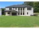 Spacious backyard with a white brick house, covered porch, and lush green lawn at 3240 Miller Bottom Rd, Conyers, GA 30012
