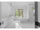 Sleek bathroom featuring a freestanding tub, double vanity, and marble-look tiled shower at 3240 Miller Bottom Rd, Conyers, GA 30012