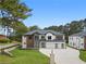 Well-manicured lawn and landscaping surround this modern home with a multi-car garage, brick and wood accents, providing great curb appeal at 3240 Miller Bottom Rd, Conyers, GA 30012