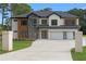 Modern home featuring a multi-car garage, brick accents, complemented by a well-manicured lawn and contemporary design elements at 3240 Miller Bottom Rd, Conyers, GA 30012