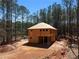 Two-story home under construction with a wooded lot, showcasing the framing and initial roof work at 3240 Miller Bottom Rd, Conyers, GA 30012