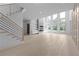 Bright living room with expansive windows, sleek fireplace and shelving, with light hardwood flooring, and modern staircase at 3240 Miller Bottom Rd, Conyers, GA 30012