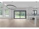 Open concept living area with large windows, wood flooring and a modern chandelier at 3240 Miller Bottom Rd, Conyers, GA 30012