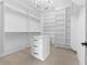 Bright walk-in closet featuring custom white shelving, a storage cabinet, and wood floor at 3240 Miller Bottom Rd, Conyers, GA 30012