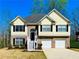 Charming two-story home with a combination of yellow siding and brick facade, enhanced by a manicured front lawn at 4962 Newpark Nw Ln, Acworth, GA 30101