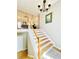 Elegant staircase with wood steps and white railings, illuminated by a chandelier, adds a touch of sophistication at 4962 Newpark Nw Ln, Acworth, GA 30101