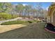 Spacious backyard with lush greenery, mature trees, a play set, and patio seating at 548 Lawton Bridge Sw Rd, Smyrna, GA 30082