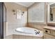 Bright bathroom featuring a shower, bathtub, window, and vanity with beige tile at 548 Lawton Bridge Sw Rd, Smyrna, GA 30082