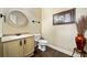 Powder room featuring a vanity with sink, toilet, and decorative accents at 548 Lawton Bridge Sw Rd, Smyrna, GA 30082