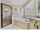 Bright bathroom featuring a shower, bathtub, window, and vanity with beige tile at 548 Lawton Bridge Sw Rd, Smyrna, GA 30082