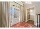 Bright foyer with a glass-paneled front door, hardwood floors, flowing curtains, and elegant decor at 548 Lawton Bridge Sw Rd, Smyrna, GA 30082