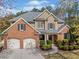 Beautiful brick and tan home featuring a two-car garage, well-manicured landscaping, and a charming covered front porch at 548 Lawton Bridge Sw Rd, Smyrna, GA 30082
