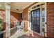 Inviting front porch with rocking chairs and decorative plants, complementing the brick facade and detailed front door at 548 Lawton Bridge Sw Rd, Smyrna, GA 30082