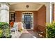 Charming front porch with brick detailing, rocking chairs, and a bench, creating a welcoming entrance at 548 Lawton Bridge Sw Rd, Smyrna, GA 30082