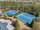 Aerial view of tennis courts with blue and green surfaces surrounded by trees in a well-maintained community at 548 Lawton Bridge Sw Rd, Smyrna, GA 30082