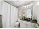 Traditional bathroom with a shower-tub combo, vanity with dark countertop, and decorative wallpaper at 2376 Massey Ln, Decatur, GA 30033