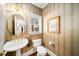 Powder room featuring a pedestal sink, decorative wallpaper, and wood floors at 2376 Massey Ln, Decatur, GA 30033