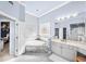 Elegant bathroom with a corner tub, marble surround, a stained glass window, and white cabinets at 2376 Massey Ln, Decatur, GA 30033