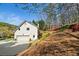 Back exterior view of home with large garage, lush landscaping, and a private deck at 2376 Massey Ln, Decatur, GA 30033