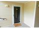 Condo front entrance with neutral siding and secured by a storm door, complete with a welcome mat at 5204 Waldrop, Decatur, GA 30034