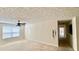Bright living room featuring neutral walls and carpet, ceiling fan, and a view into the hall at 5204 Waldrop, Decatur, GA 30034