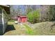 An outbuilding sits in the backyard featuring trees and shrubbery at 528 Lower Scott Mill Rd, Canton, GA 30114