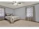 Relaxing bedroom featuring soft carpet, a ceiling fan, and natural light from two large windows at 528 Lower Scott Mill Rd, Canton, GA 30114