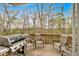 Relax on this outdoor deck featuring three chairs, a grill, and views of mature trees at 822 Pine Way, Dallas, GA 30157