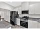 Modern kitchen features black appliances, granite countertops and white cabinetry, perfect for cooking at 822 Pine Way, Dallas, GA 30157