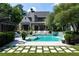 Beautiful backyard oasis with a sparkling pool, waterfall feature, lush landscaping, and elegant home exterior at 5495 Mount Vernon Pkwy, Atlanta, GA 30327