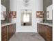 Bright bathroom featuring a double vanity, stone floor, and decorative mirror reflecting the tub and chandelier at 5495 Mount Vernon Pkwy, Atlanta, GA 30327