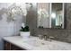 Close up of bathroom vanity featuring white marble countertop, gray mosaic tile backsplash, and modern faucet at 5495 Mount Vernon Pkwy, Atlanta, GA 30327