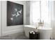 Elegant bathroom featuring a soaking tub, painting, and herringbone patterned floor with a marble wall at 5495 Mount Vernon Pkwy, Atlanta, GA 30327