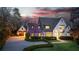 Charming home exterior with manicured lawn and a circular driveway at twilight at 5495 Mount Vernon Pkwy, Atlanta, GA 30327