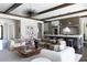 Open concept living room leads into the kitchen for entertaining with hardwood floors and wood ceiling beams at 5495 Mount Vernon Pkwy, Atlanta, GA 30327