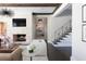 Bright and airy living room features a stone fireplace, modern lighting, and staircase access at 5495 Mount Vernon Pkwy, Atlanta, GA 30327