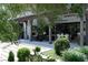 Covered outdoor living space with a fireplace, modern furnishings, and elegant landscaping at 5495 Mount Vernon Pkwy, Atlanta, GA 30327