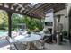 Inviting covered patio with dining area, fireplace, ceiling fans, outdoor kitchen and view of backyard pool and pergola at 5495 Mount Vernon Pkwy, Atlanta, GA 30327
