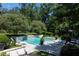 Aerial view of a pristine pool, lounge area, waterfall feature, and a covered outdoor space at 5495 Mount Vernon Pkwy, Atlanta, GA 30327