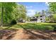Expansive backyard with lush green lawn, mature trees, and a screened porch at 110 Myers Dr, Alpharetta, GA 30009
