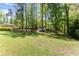 Expansive backyard with mature trees, a fire pit, and a storage shed at 110 Myers Dr, Alpharetta, GA 30009
