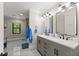 Bright bathroom features double vanity with modern fixtures and mirrors and gray cabinets at 110 Myers Dr, Alpharetta, GA 30009