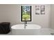 Close-up of a freestanding bathtub in a bathroom with a large window and modern fixtures at 110 Myers Dr, Alpharetta, GA 30009