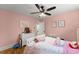 Bedroom with bright pink walls featuring hardwood floors, a ceiling fan, and a window at 110 Myers Dr, Alpharetta, GA 30009
