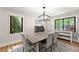 Bright dining room with a wooden table, comfortable seating, modern lighting, and scenic outdoor views at 110 Myers Dr, Alpharetta, GA 30009