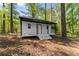 Charming white cottage with a covered porch, nestled in a wooded, leafy setting at 110 Myers Dr, Alpharetta, GA 30009