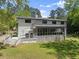 Rear exterior view showcasing a spacious deck, screened porch, and landscaped lawn at 110 Myers Dr, Alpharetta, GA 30009